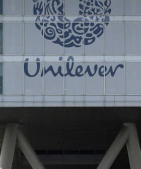 Exterior view of the Unilever headquarters building featuring a large logo and glass facade. - Olive Oil Times