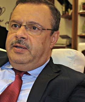 Agriculture Minister Samir Taieb seated in an office with a flag in the background. - Olive Oil Times