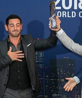 Four men at the 2018 New York Olive Oil Competition, one holding an award while others applaud. - Olive Oil Times