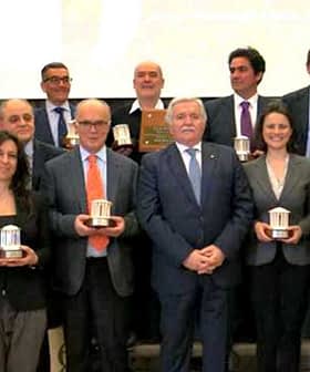 Group photo of winners holding awards at the 26th Ercole Olivario event. - Olive Oil Times