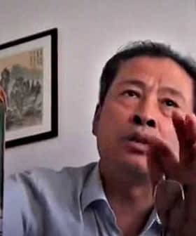 Individual holding a large plastic bottle of oil while speaking during a video call. - Olive Oil Times