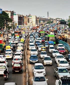 A congested urban street filled with various vehicles including cars, buses, and trucks during daytime. - Olive Oil Times