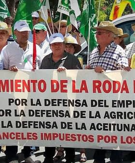 Group of protesters holding a large banner advocating for agricultural employment and olive oil support. - Olive Oil Times