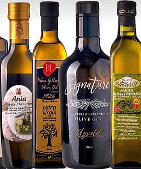 Various bottles of olive oil displayed in a row, featuring different designs and labels. - Olive Oil Times