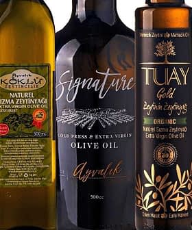 Assorted olive oil bottles displayed in a row with different labels and designs. - Olive Oil Times
