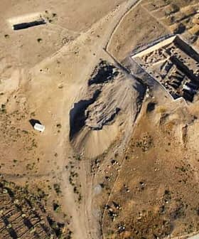 Aerial view of an archaeological site with excavation areas and surrounding terrain. - Olive Oil Times