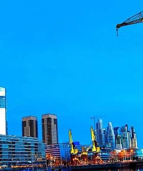 View of the Puerto Madero waterfront in Buenos Aires featuring modern buildings and a crane. - Olive Oil Times