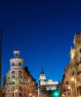 Night view of a cityscape in Madrid featuring illuminated buildings and streetlights. - Olive Oil Times
