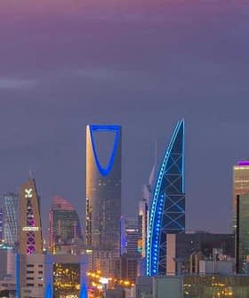 Skyline of Riyadh featuring modern skyscrapers illuminated at dusk with a purple sky. - Olive Oil Times