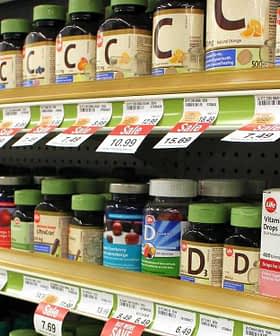 Various bottles of dietary supplements displayed on a store shelf with price tags. - Olive Oil Times