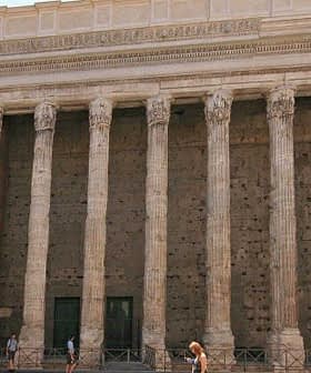 The Temple of Hadrian in Rome features tall columns and a stone facade with a historical architectural design. - Olive Oil Times