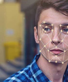 Young man with facial recognition overlay and processing indicator on his face while looking at a device. - Olive Oil Times