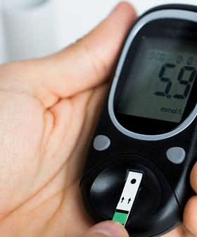 Person holding a blood glucose meter displaying a reading of 5.9 mmol/L. - Olive Oil Times