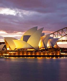 Sydney Opera House illuminated at sunset with the Harbour Bridge in the background. - Olive Oil Times