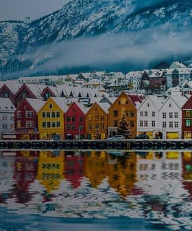 Row of colorful waterfront houses reflecting in the water in Bergen, Norway during winter. - Olive Oil Times