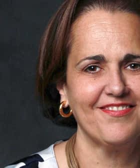 Portrait of a woman with short brown hair wearing hoop earrings and a striped top. - Olive Oil Times