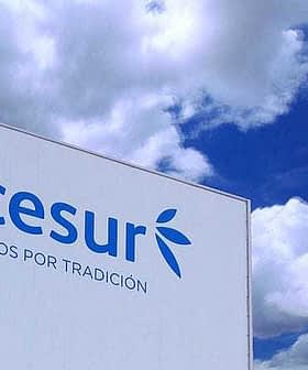 Signage displaying the Acesur logo and slogan against a blue sky with clouds. - Olive Oil Times