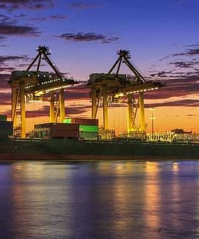 Cargo ship docked at a port with cranes and containers during a sunset. - Olive Oil Times
