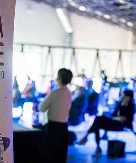 Banner for Terra Madre Salone del Gusto event with audience in the background. - Olive Oil Times