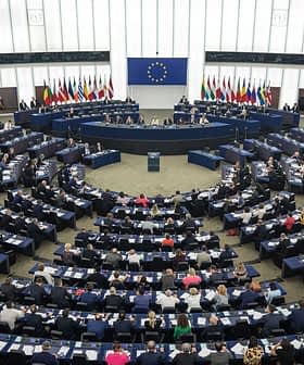 Interior view of the European Parliament in session with members seated in a circular arrangement. - Olive Oil Times