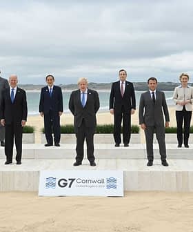 Group photo of G7 leaders standing on a stage at a beach in Cornwall. - Olive Oil Times