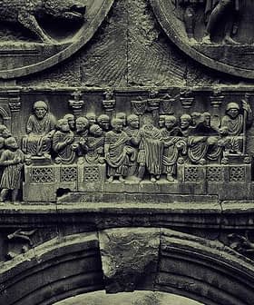 Detailed stone relief depicting historical figures and scenes in intricate carvings. - Olive Oil Times