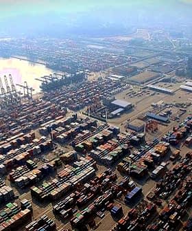 Aerial view of a busy container port with numerous shipping containers stacked. - Olive Oil Times
