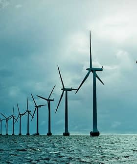 Row of offshore wind turbines standing in the ocean under a cloudy sky. - Olive Oil Times