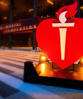 Large red heart symbol with a torch in front of a convention center entrance. - Olive Oil Times