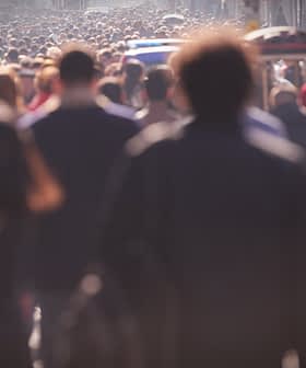 A large crowd of people walking on a busy city street during daylight hours. - Olive Oil Times