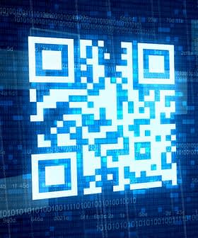A blue QR code displayed on a digital background with binary code elements. - Olive Oil Times