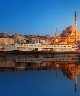 A ferry docked near a mosque in Istanbul during sunset with reflections on the water. - Olive Oil Times