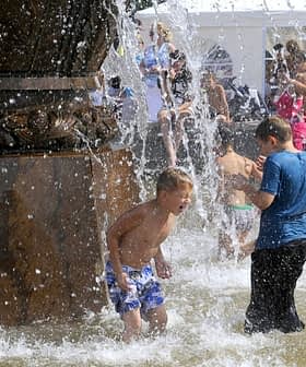 Children splashing water while playing in a fountain on a sunny day. - Olive Oil Times