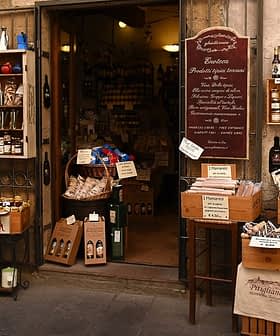 Entrance of an Italian specialty food store with various products displayed outside. - Olive Oil Times
