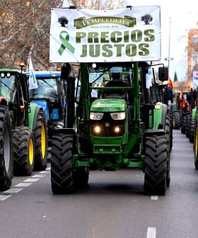 Line of tractors in a protest march displaying a banner that reads 'Precios Justos'. - Olive Oil Times