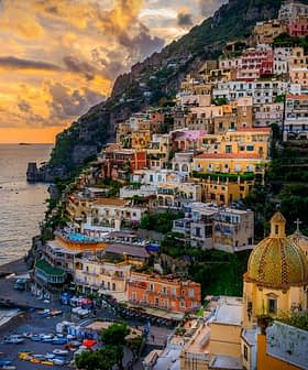 View of the coastal town of Positano with colorful buildings and a beach during sunset. - Olive Oil Times