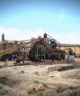 Industrial machinery and equipment at a construction site with various structures and conveyor belts. - Olive Oil Times