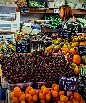 A vibrant display of various fruits and vegetables at a market stall with price tags. - Olive Oil Times