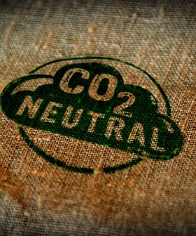 Green CO2 neutral stamp printed on a textured fabric background. - Olive Oil Times