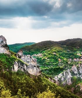 A panoramic view of a mountainous landscape featuring prominent rock formations and greenery. - Olive Oil Times