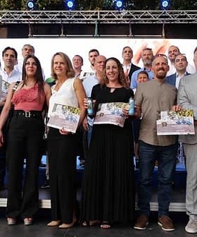 Group of people posing together at an award ceremony with certificates in hand. - Olive Oil Times