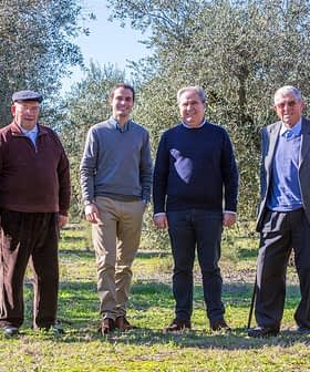Six men standing together in an olive grove, dressed in casual and formal attire. - Olive Oil Times
