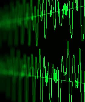 Digital representation of sound waves displayed in green on a dark background. - Olive Oil Times