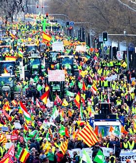 A large crowd of demonstrators with tractors and flags participating in a protest. - Olive Oil Times