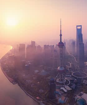 Aerial view of Shanghai skyline featuring the Oriental Pearl Tower and skyscrapers during sunset. - Olive Oil Times