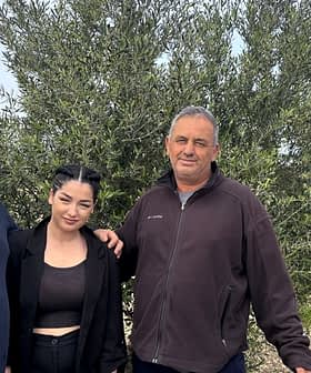 Three individuals standing together in front of an olive tree in an outdoor setting. - Olive Oil Times
