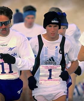 Three male runners participating in a competitive race, wearing athletic gear and numbers on their shirts. - Olive Oil Times