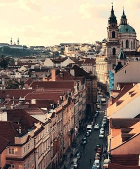 Aerial view of Prague showcasing rooftops and St. Nicholas Church in the background. - Olive Oil Times