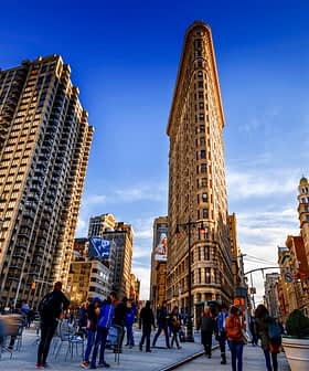 New York şehrindeki Flatiron Binası, etrafı diğer binalarla çevrili tarihi üçgen bir gökdelen. - Olive Oil Times