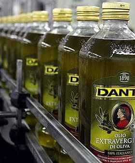 Red boca ekstra djevičanskog maslinovog ulja Dante na proizvodnoj liniji u tvorničkom okruženju. - Olive Oil Times